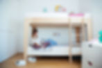 A girl sitting on her bunk bed reading a book