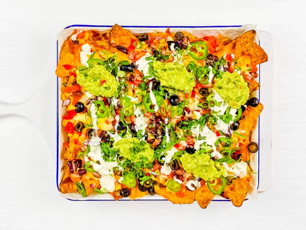 Loaded meatless nachos on a white platter.