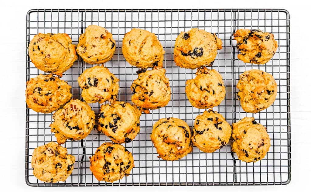 Fruitcake cookies fresh out of the oven, cooling on a wire rack.