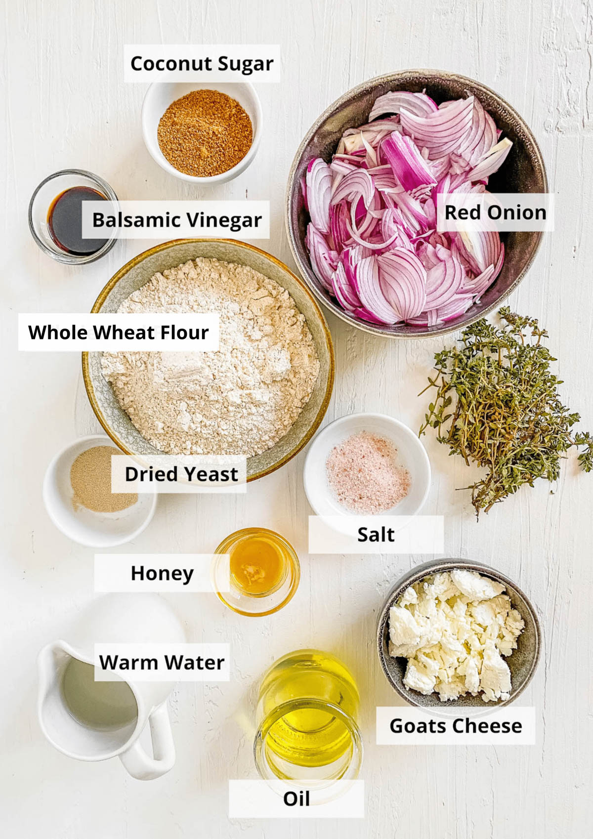 Ingredients for caramelized onion and goat cheese pizza recipe on a white background.