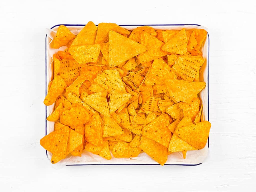 Tortilla chips in a single layer on a baking sheet.