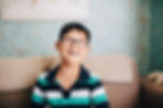 A boy with special needs wearing glasses and smiling