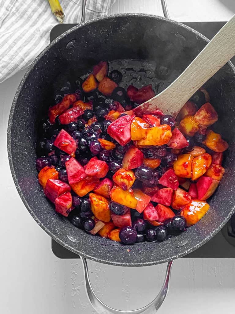 cooked blueberries mangoes apples in a pot