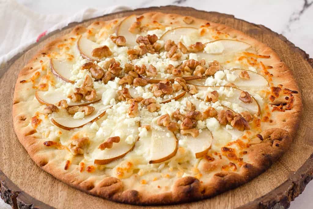 pear gorgonzola pizza served on a wooden cutting board