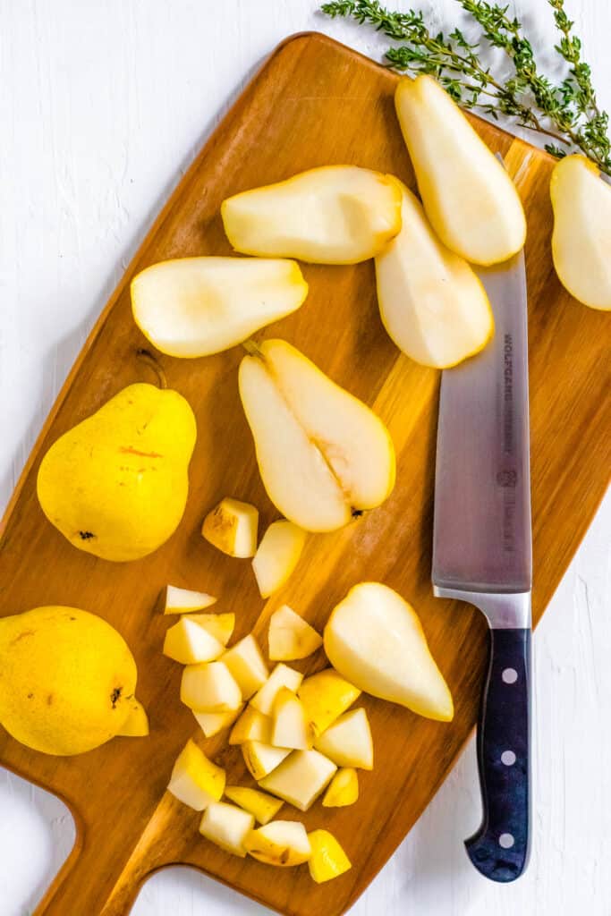 Pears cut on a wooden cutting board.